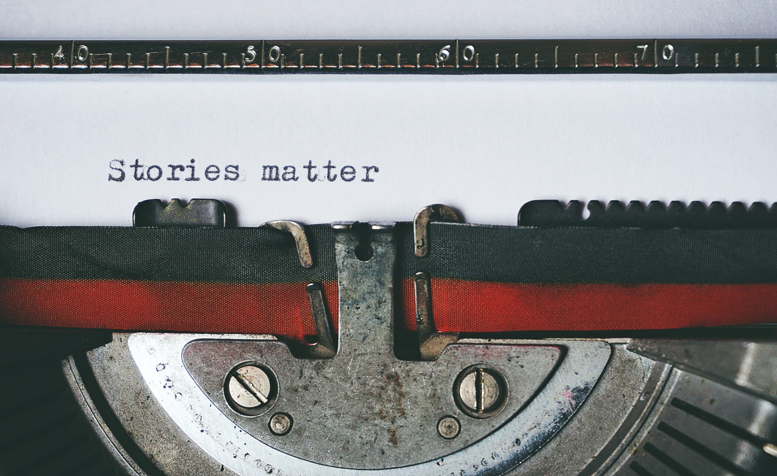 black and red typewriter with the text "stories matter"